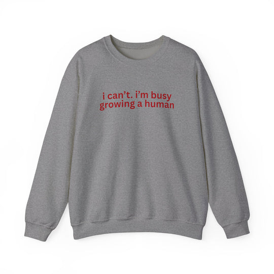 Heather-gray crewneck sweatshirt with bold red text, I can’t. i’m busy growing a human. Comfortable unisex fit from Faith Family Designs.