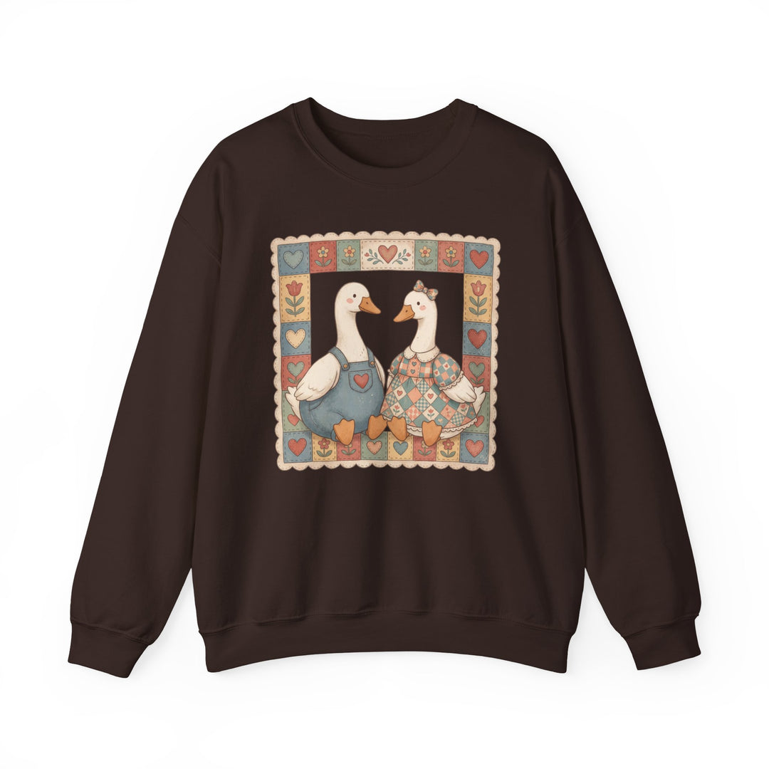 Thrifted Geese Crew sweatshirt features folk-art ducks in pastel attire within a patchwork border, offering comfort with a polyester-cotton blend and ribbed collar.