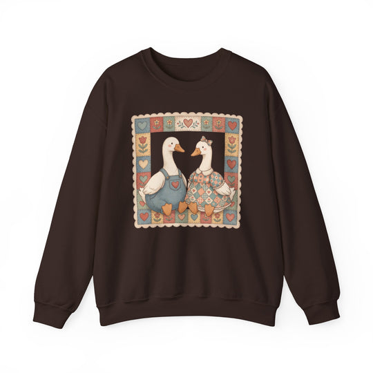 Thrifted Geese Crew sweatshirt features folk-art ducks in pastel attire within a patchwork border, offering comfort with a polyester-cotton blend and ribbed collar.