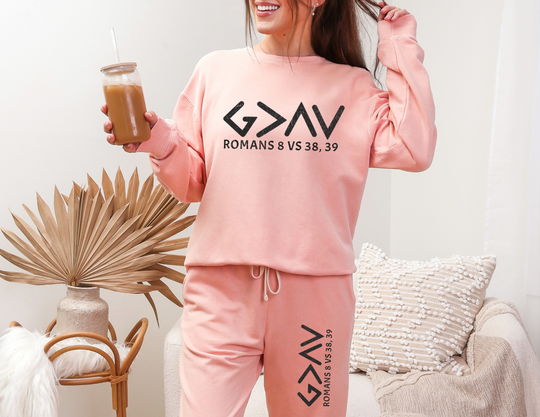 Woman holding a drink, wearing God is Greater Sweatpants. Relaxed fit, medium fabric, vintage style, crafted from 100% ring-spun cotton. Retro-inspired design.