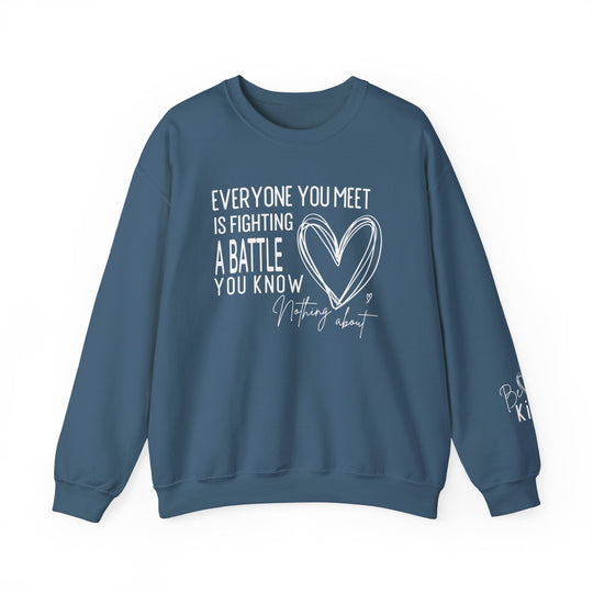 Slate-blue crewneck sweatshirt with Everyone You Meet is Fighting a Battle You Know Nothing About in white hand-lettered style; right sleeve reads Be Kind.