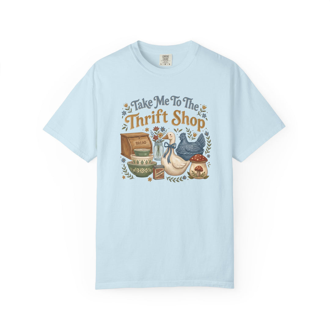 Take Me To The Thrift Shop Tee featuring a vintage still-life graphic with thrifted items, capturing a retro, playful theme on a pale-blue Comfort Colors T-shirt.