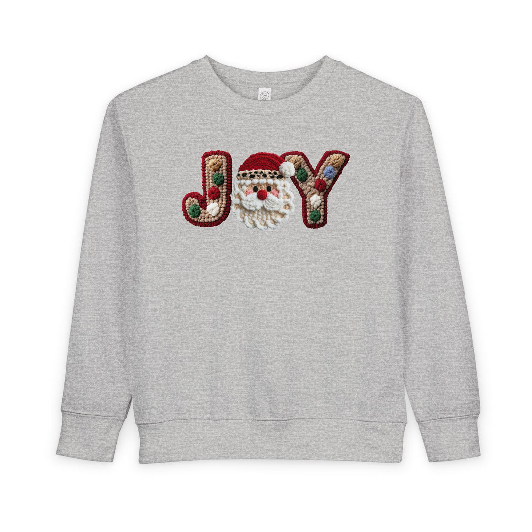Heather-gray Joy Toddler Crew sweatshirt with festive JOY applique, featuring chunky yarn letters and a crocheted Santa face, perfect for cozy, playful holiday wear.