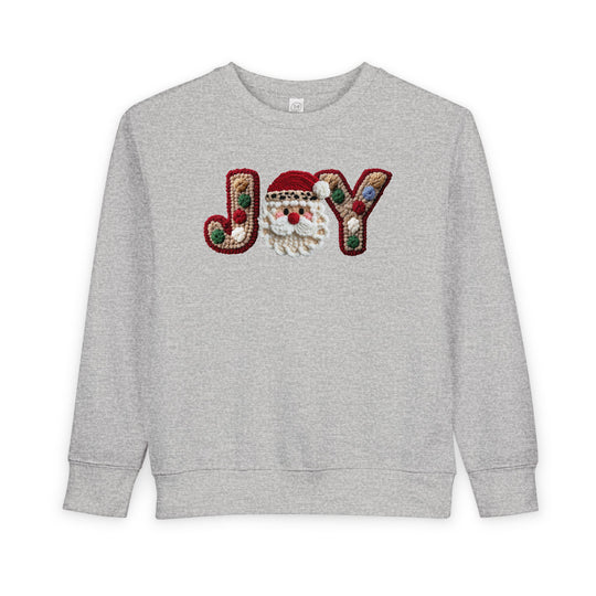 Heather-gray Joy Toddler Crew sweatshirt with festive JOY applique, featuring chunky yarn letters and a crocheted Santa face, perfect for cozy, playful holiday wear.
