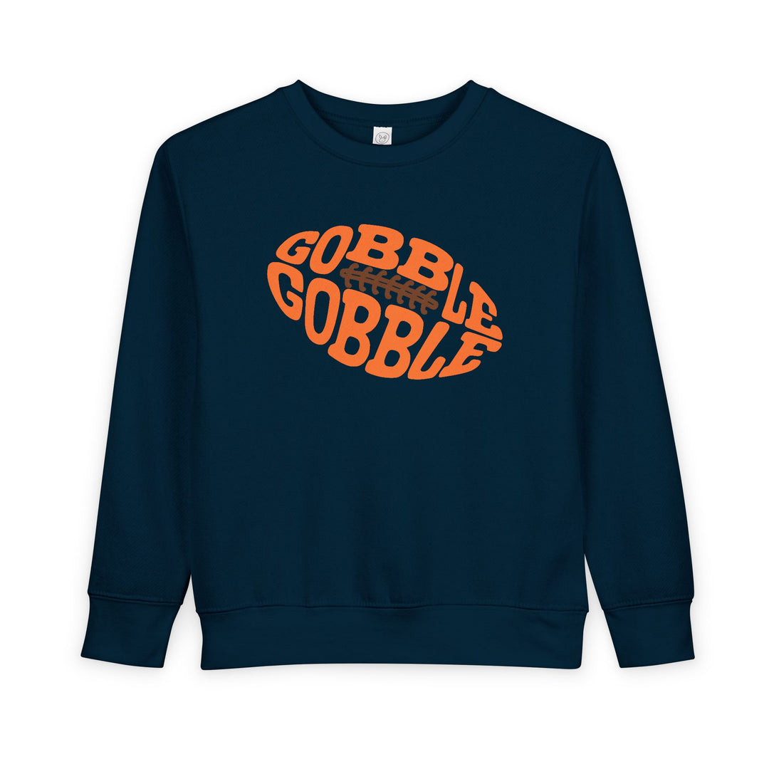 Dark-navy toddler sweatshirt featuring a vibrant orange football graphic with GOBBLE GOBBLE text, designed for comfort and durability by Faith Family Designs.