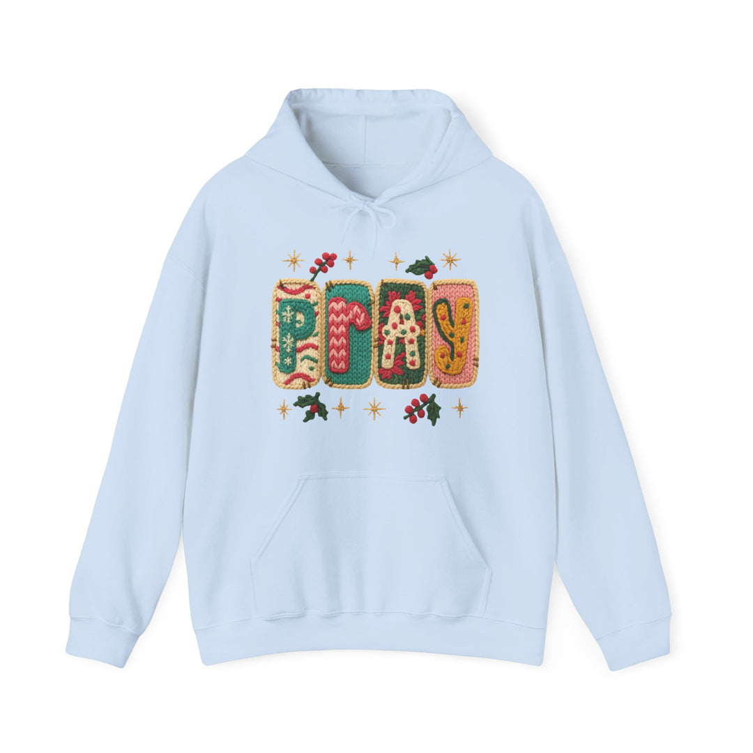 Light-blue Pray Hoodie with festive knitted-style graphic, featuring Pray blocks, holly sprigs, gold stars. Cozy unisex design with kangaroo pocket, drawstring hood.