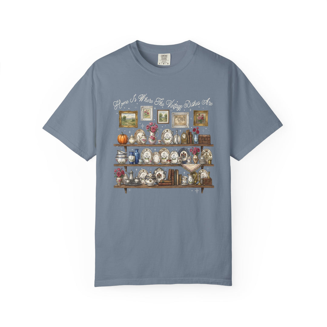 Vintage Dishes Tee featuring a vintage-kitchen illustration of shelves with antique dishes, books, and floral decor, topped with Home Is Where The Vintage Dishes Are slogan.