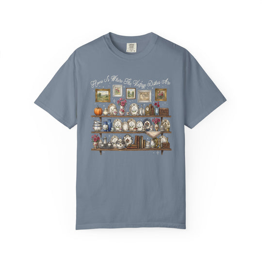 Vintage Dishes Tee featuring a vintage-kitchen illustration of shelves with antique dishes, books, and floral decor, topped with Home Is Where The Vintage Dishes Are slogan.