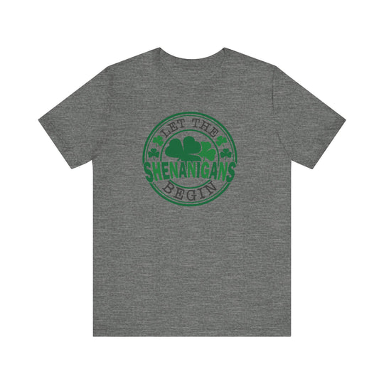 Back of grey 'Let The Shenanigans Begin' tee featuring a green and black circular clover logo, designed for comfort and style.