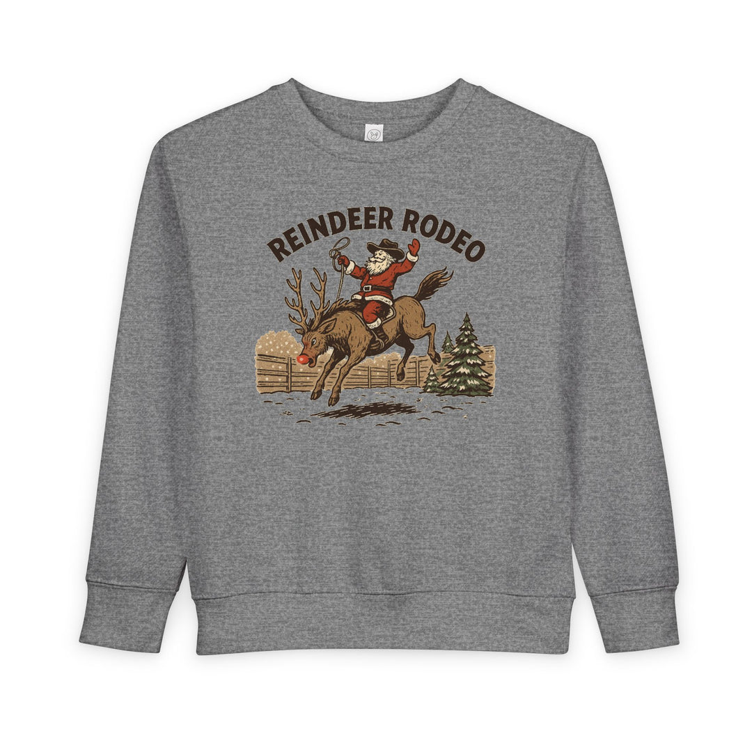 Reindeer Toddler Crew: Light-gray sweatshirt featuring Santa in cowboy attire on a bucking reindeer, set against a snowy corral and fir tree, for festive toddler wear.