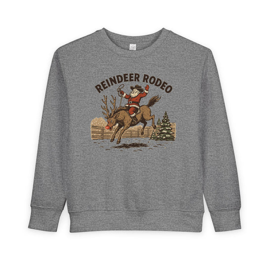 Reindeer Toddler Crew: Light-gray sweatshirt featuring Santa in cowboy attire on a bucking reindeer, set against a snowy corral and fir tree, for festive toddler wear.