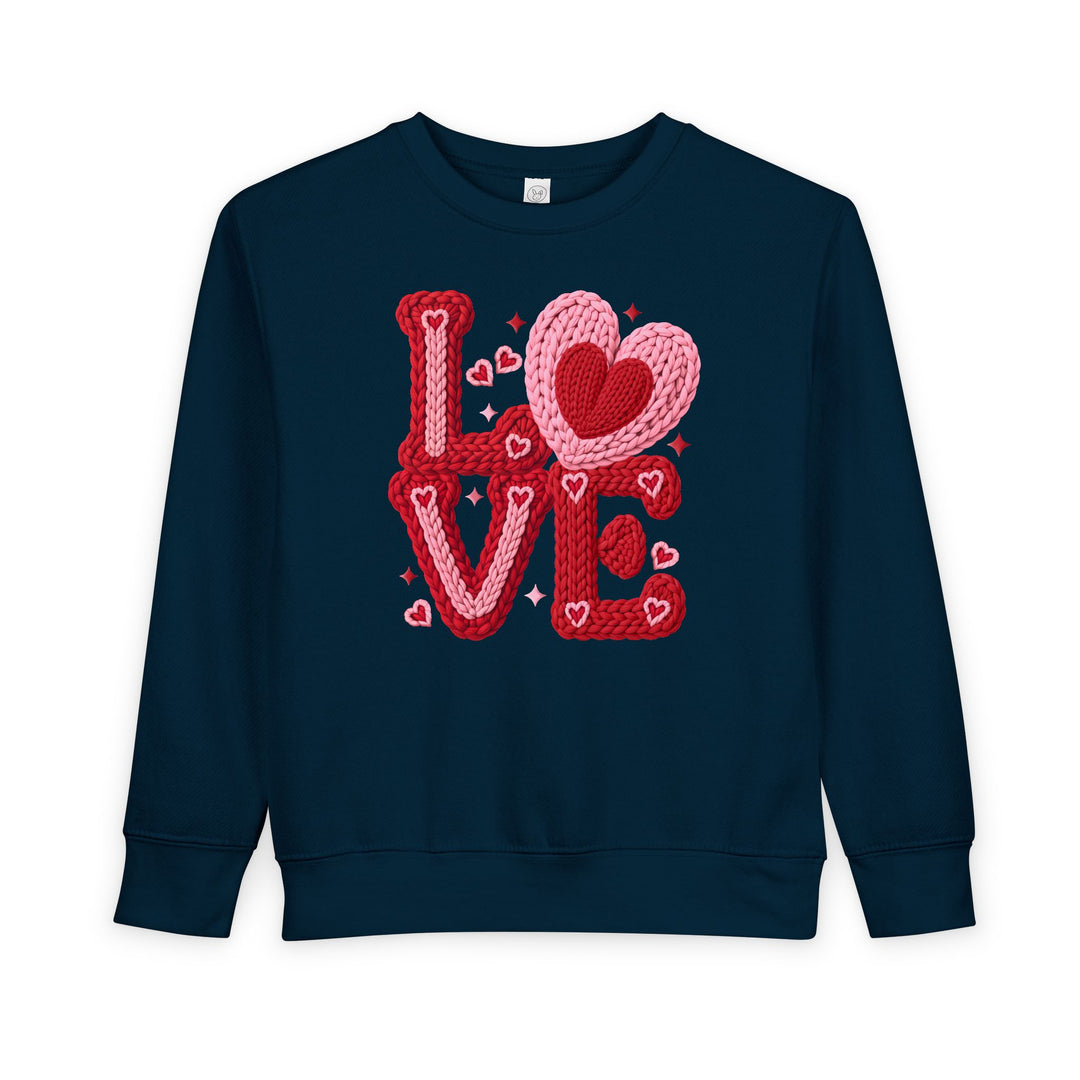 Love Heart Toddler Crew sweatshirt with LOVE in red-pink chunky knit letters, heart accents; soft, durable fleece, perfect for keeping toddlers warm and stylish.