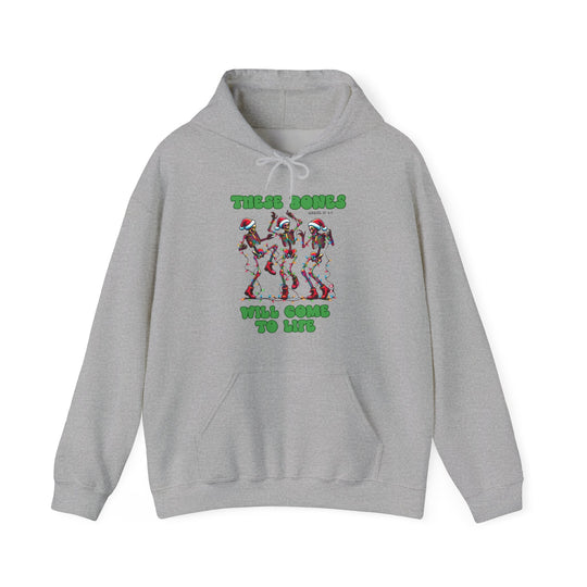 Bones Come to Life Hoodie featuring dancing skeletons in Santa hats with Christmas lights, green bubble text, and Ezekiel 37: 1-5 reference, ideal for festive warmth.