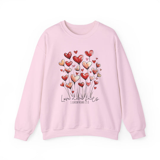 Love Never Fails Crew: Light pink sweatshirt with heart blooms, featuring Love never fails and 1 Corinthians 13:8 in script. Cozy, ribbed collar, unisex fit.