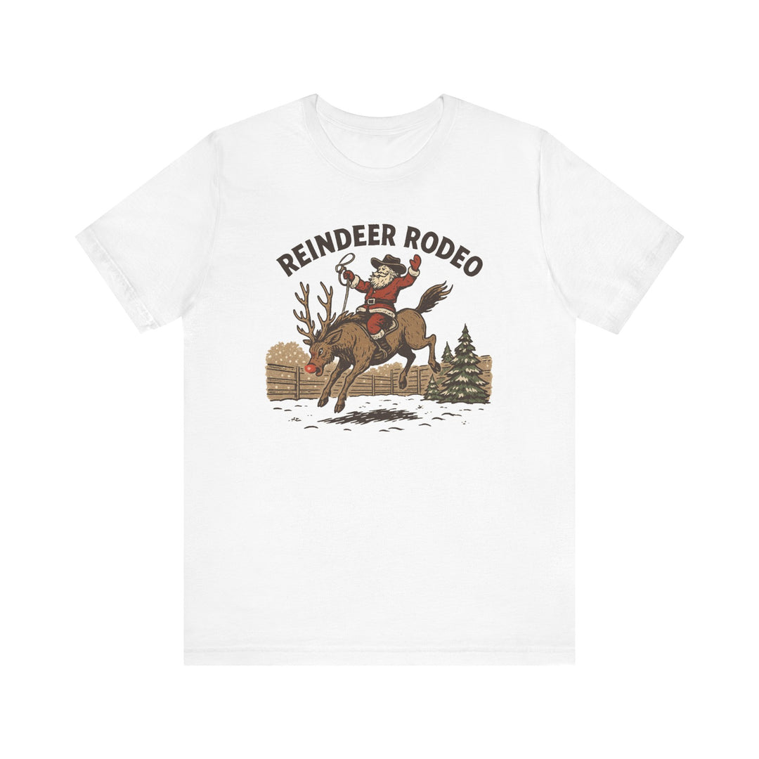 Reindeer Rodeo Tee featuring Santa as a rodeo cowboy on a bucking reindeer, perfect for adding humor to your Christmas wardrobe.