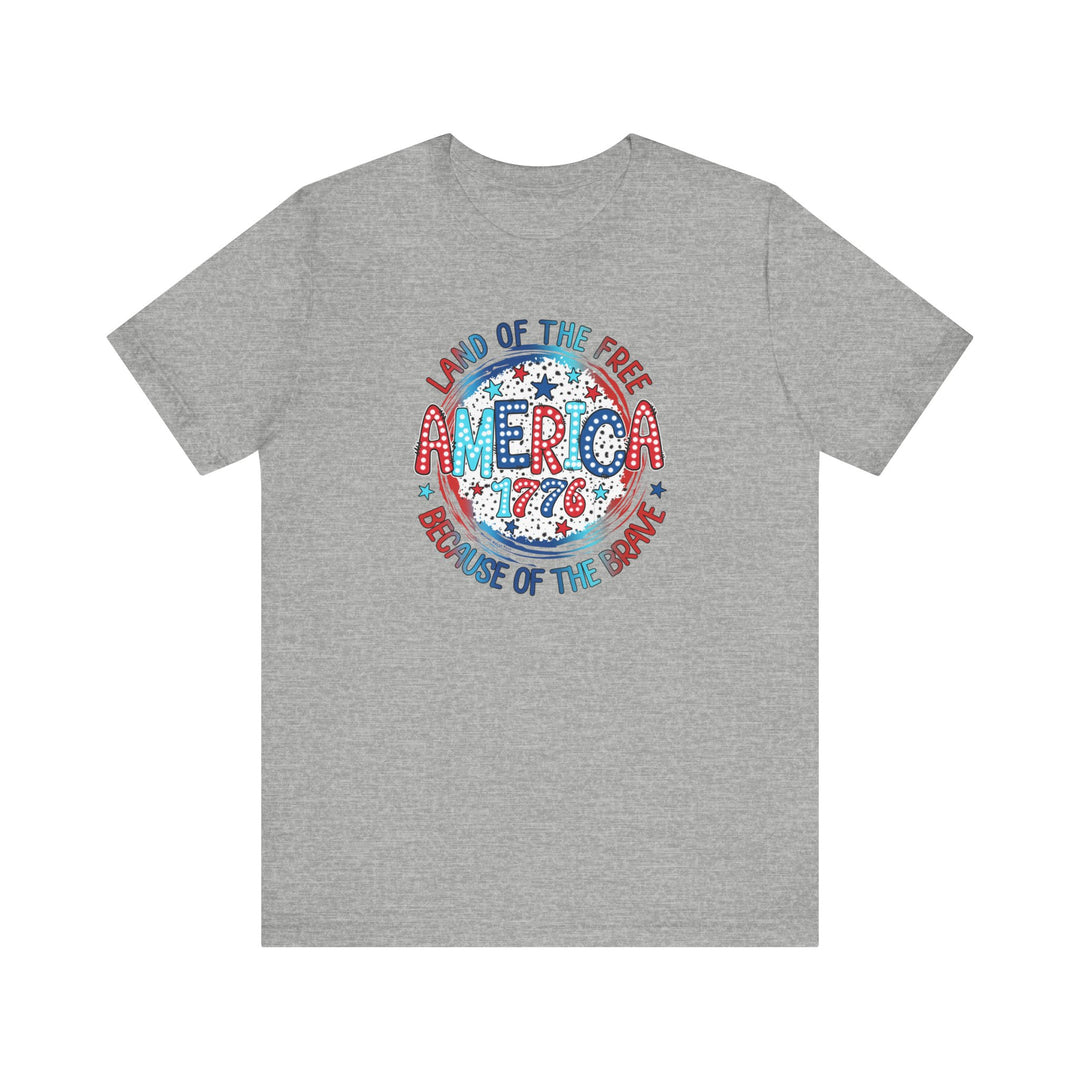 America 1776 Tee: Unisex grey t-shirt with red, white, and blue text, featuring a graphic design of stars. 100% Airlume combed cotton, retail fit, tear away label, runs true to size.