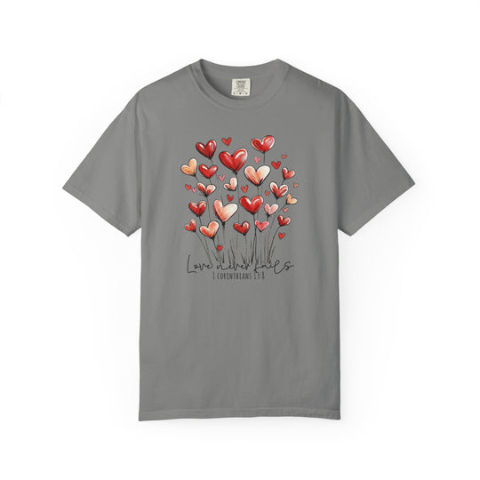 Love Never Fails Tee featuring heart-shaped blooms and scripture text on a heather-gray Comfort Colors short-sleeve shirt, embodying a message of enduring love.