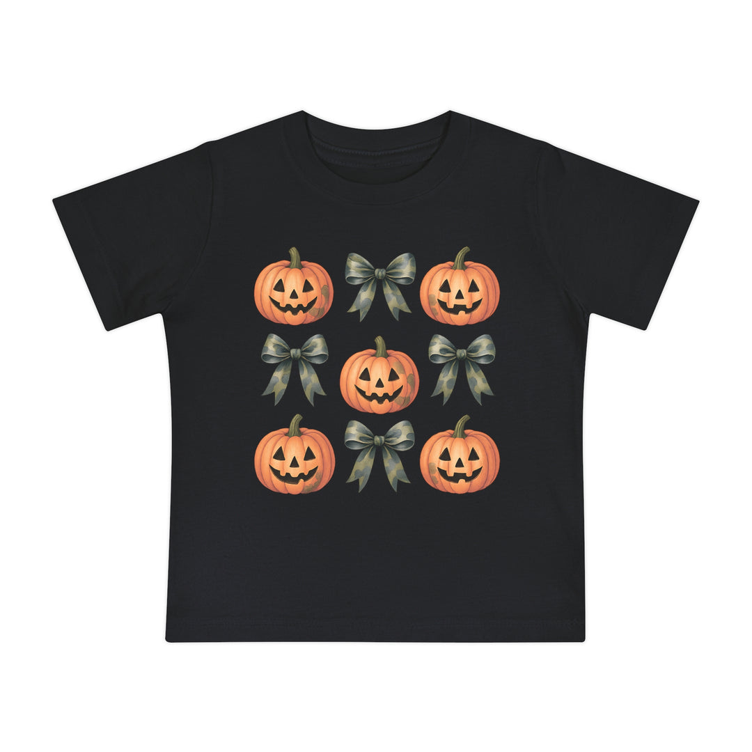 Pumpkins and Bows Baby Tee featuring a 3x3 pattern of jack-o’-lanterns and camo-style bows on a black T-shirt, offering style and comfort for little ones.