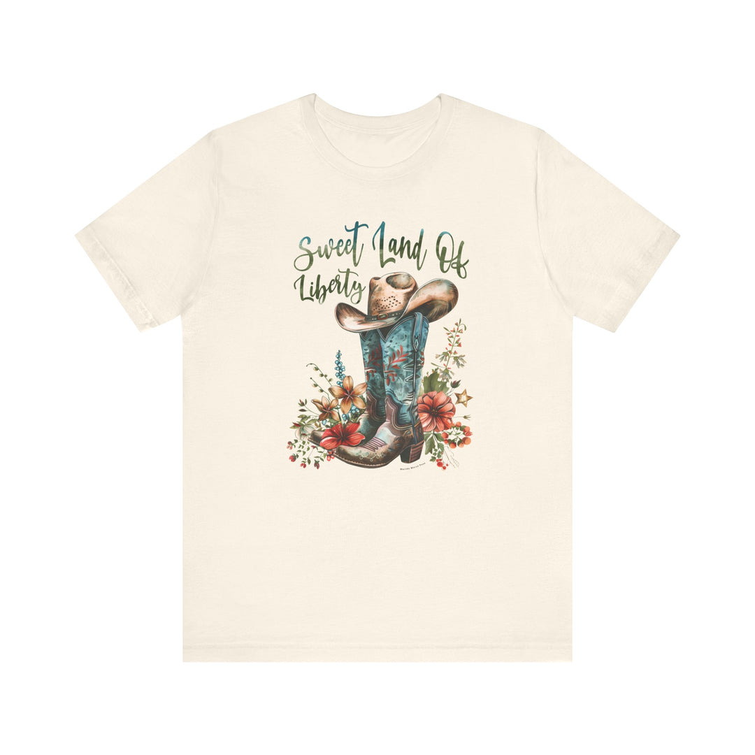 A white t-shirt featuring a cowboy hat and boots, embodying a classic Americana vibe. Made of 100% Airlume combed cotton, with ribbed knit collars and taping on shoulders for lasting comfort. Sweet Land of Liberty Tee by Worlds Worst Tees.