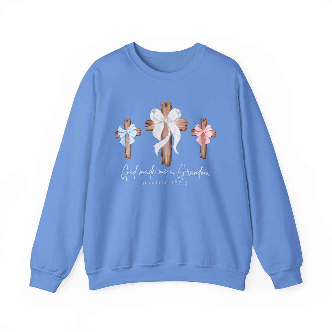 Light-blue sweatshirt with three wooden crosses and bows, God Made Me a Grandma text, Psalm 127:3. Unisex, comfortable blend, ribbed collar.