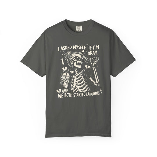 Charcoal T-shirt featuring a cartoon skeleton with sunglasses, messy bun, holding a drink, surrounded by sparkles and broken hearts. Text: I ASKED MYSELF IF I’M OKAY AND WE BOTH STARTED LAUGHING.”