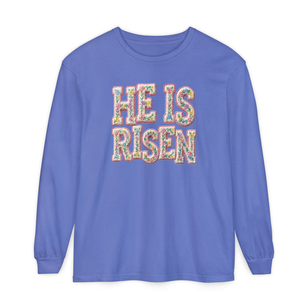 He is Risen Long Sleeve Tee in periwinkle blue with floral-patterned letters, offering a relaxed fit and soft, 100% ring-spun cotton fabric.