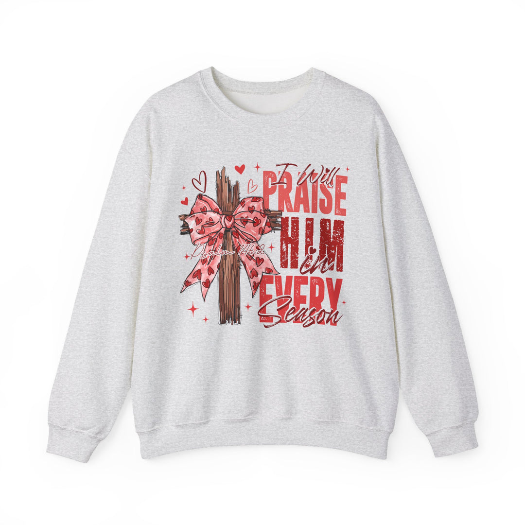 Praise in Every Season Heart Crew sweatshirt featuring a stylized wooden cross with a pink bow, surrounded by hearts and sparkles, and red text from Psalm 146:2.
