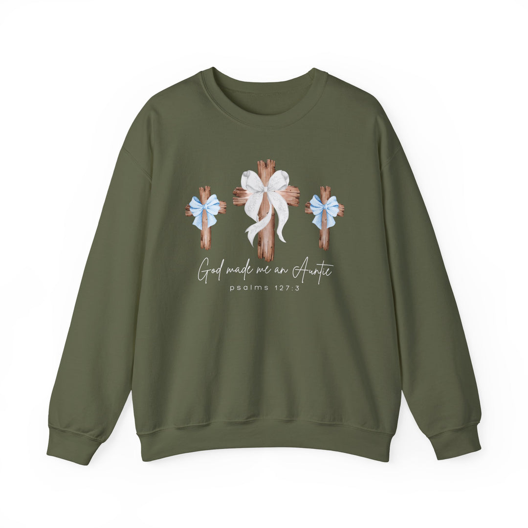 Olive-green crewneck sweatshirt with rustic wooden crosses, bows, and 'God made me an Auntie' script, referencing Psalms 127:3, from Faith Family Designs.