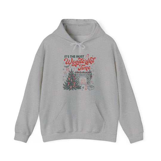 Light-gray hoodie with It's the most Wonderful Time in festive colors, featuring a Christmas tree, fireplace, stockings, and gifts. Cozy blend, ideal for cold days.
