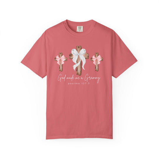 Coral-pink tee with three wooden crosses and bows, featuring God Made Me a Grammy and PSALMS 127:3. Relaxed fit, durable, customizable.