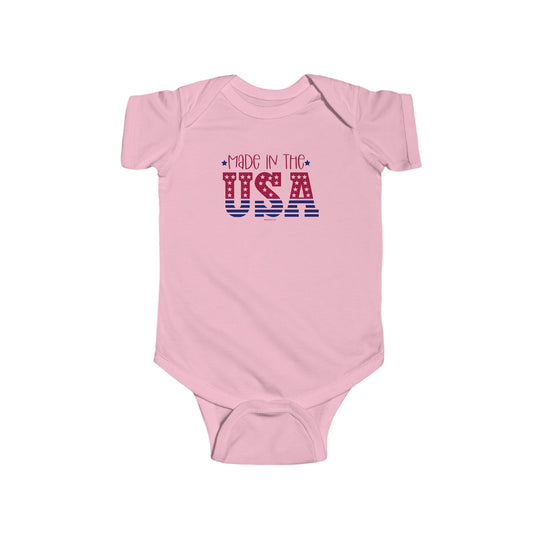 Made in the USA Onesie by Worlds Worst Tees, a pink baby bodysuit with red and blue text. 100% cotton, light fabric, ribbed knitting for durability, plastic snaps for easy changing access.