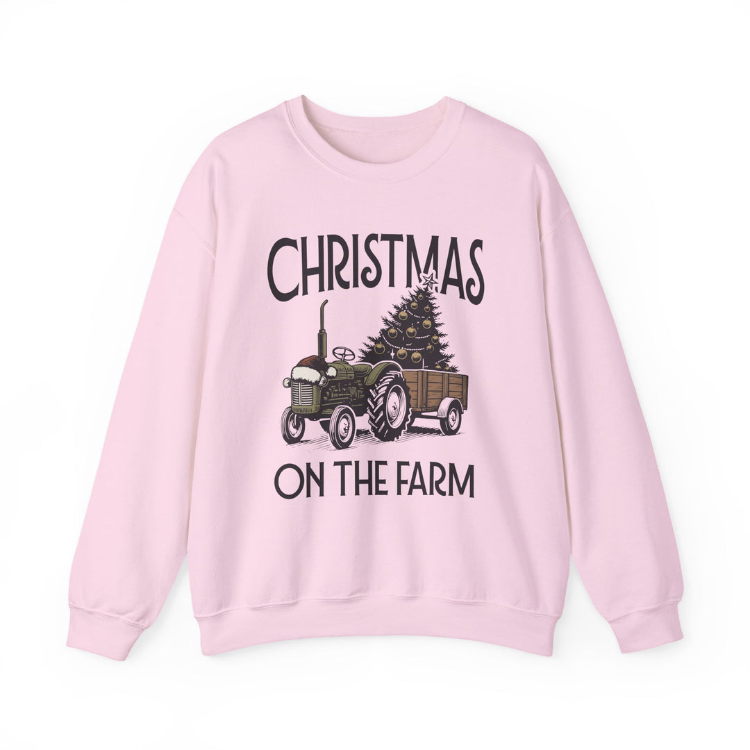 Light pink crewneck sweatshirt with CHRISTMAS ON THE FARM design, featuring a vintage green tractor and decorated tree, offering cozy comfort for colder months.