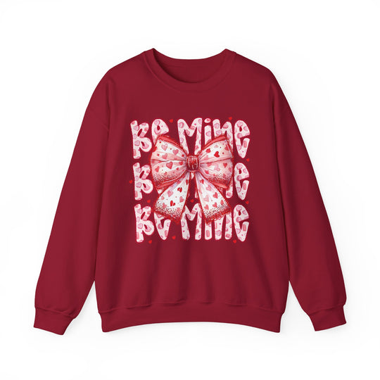 Be Mine Crew sweatshirt with a pink-and-white heart-patterned bow and BE MINE bubble letters, offering cozy comfort and a Valentine's-Day theme.