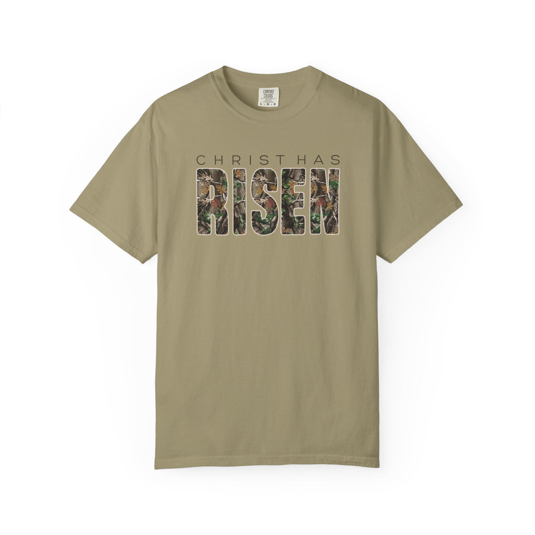 Khaki 'Christ Has Risen' tee with camouflage lettering, short sleeves, Comfort Colors label, offering relaxed fit and luxurious comfort.