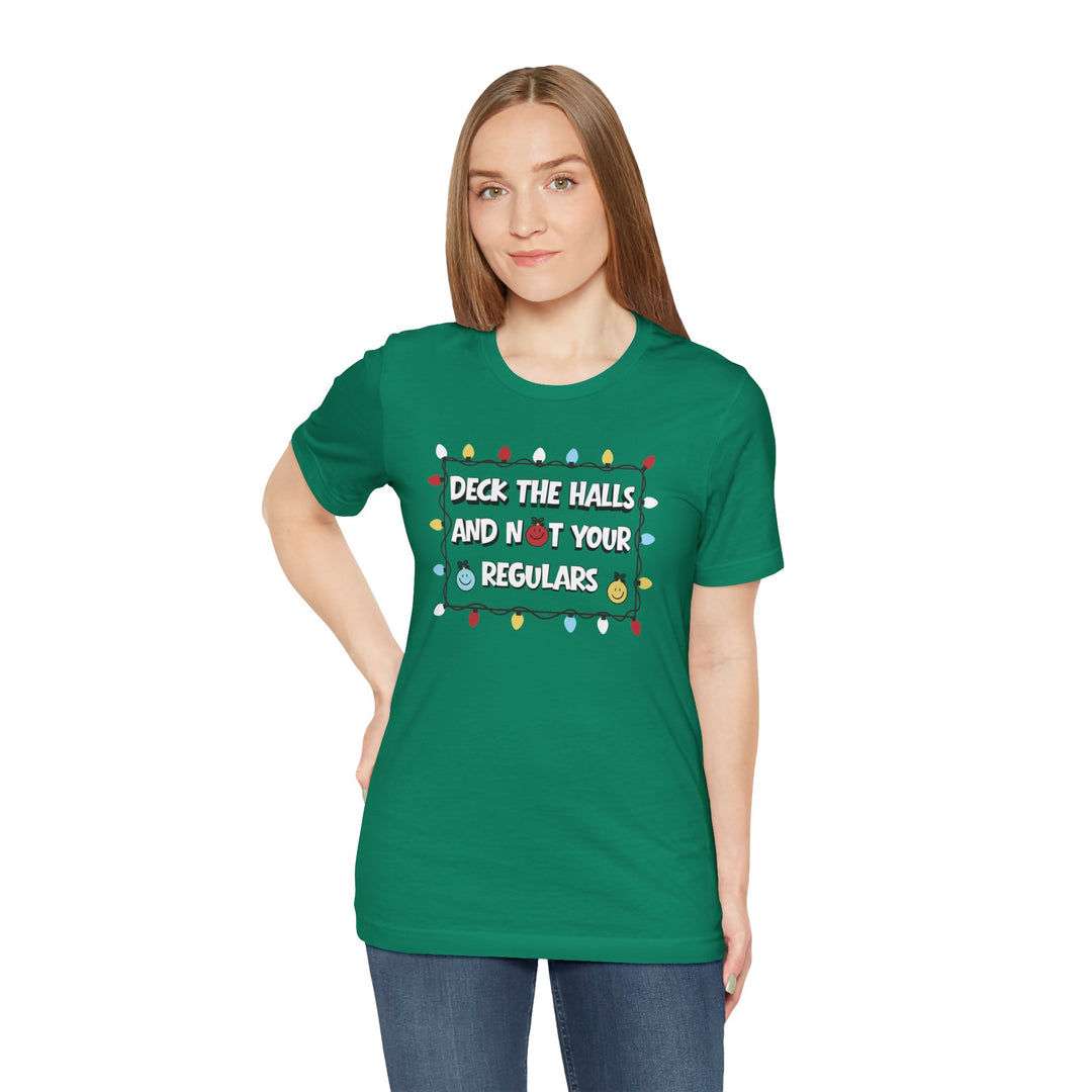 Woman wearing the Regulars Tee with a holiday design and playful text, featuring ornament-style smiley faces, over a white background.