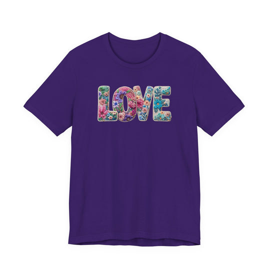 Love Spring Tee: Purple T-shirt with LOVE in vibrant, flower-studded letters, offering a soft, classic unisex fit from Faith Family Designs.