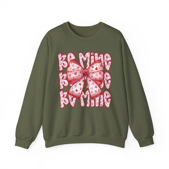 Be Mine Crew sweatshirt featuring a playful, Valentine’s-themed graphic with a pink-and-white bow and BE MINE! text in bubble letters, perfect for festive occasions.