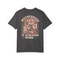 Back of dark charcoal Kingdom Work Tee with retro floral design and MOTHERHOOD IS KINGDOM WORK text, featuring Proverbs 31:25–27 snippets in small type.