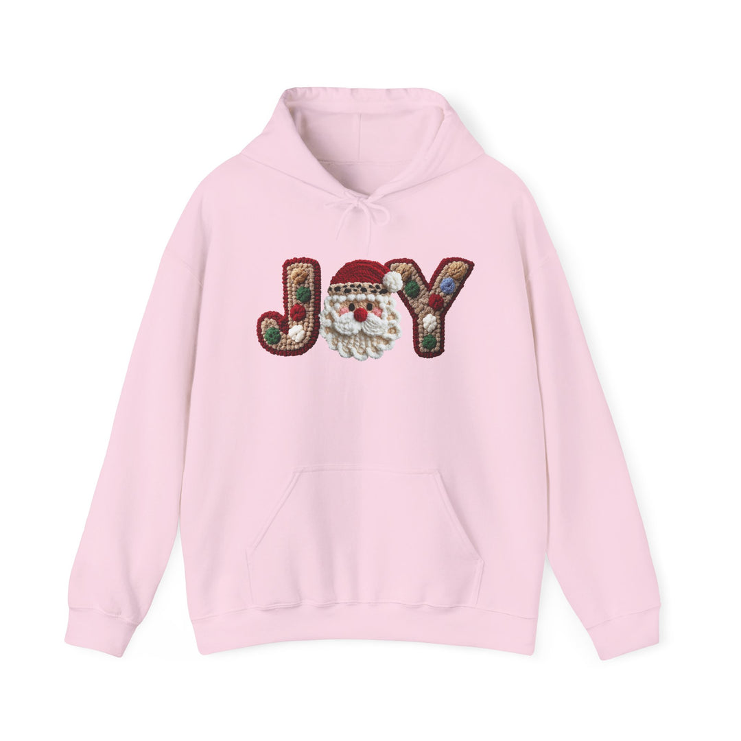 Light-pink Joy Hoodie with festive JOY design, featuring a Santa face, kangaroo pocket, and drawstring hood, blending cotton and polyester for warmth.