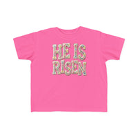 He is Risen Toddler Tee features floral-patterned lettering on a hot-pink T-shirt, designed for comfort and durability, perfect for toddlers.