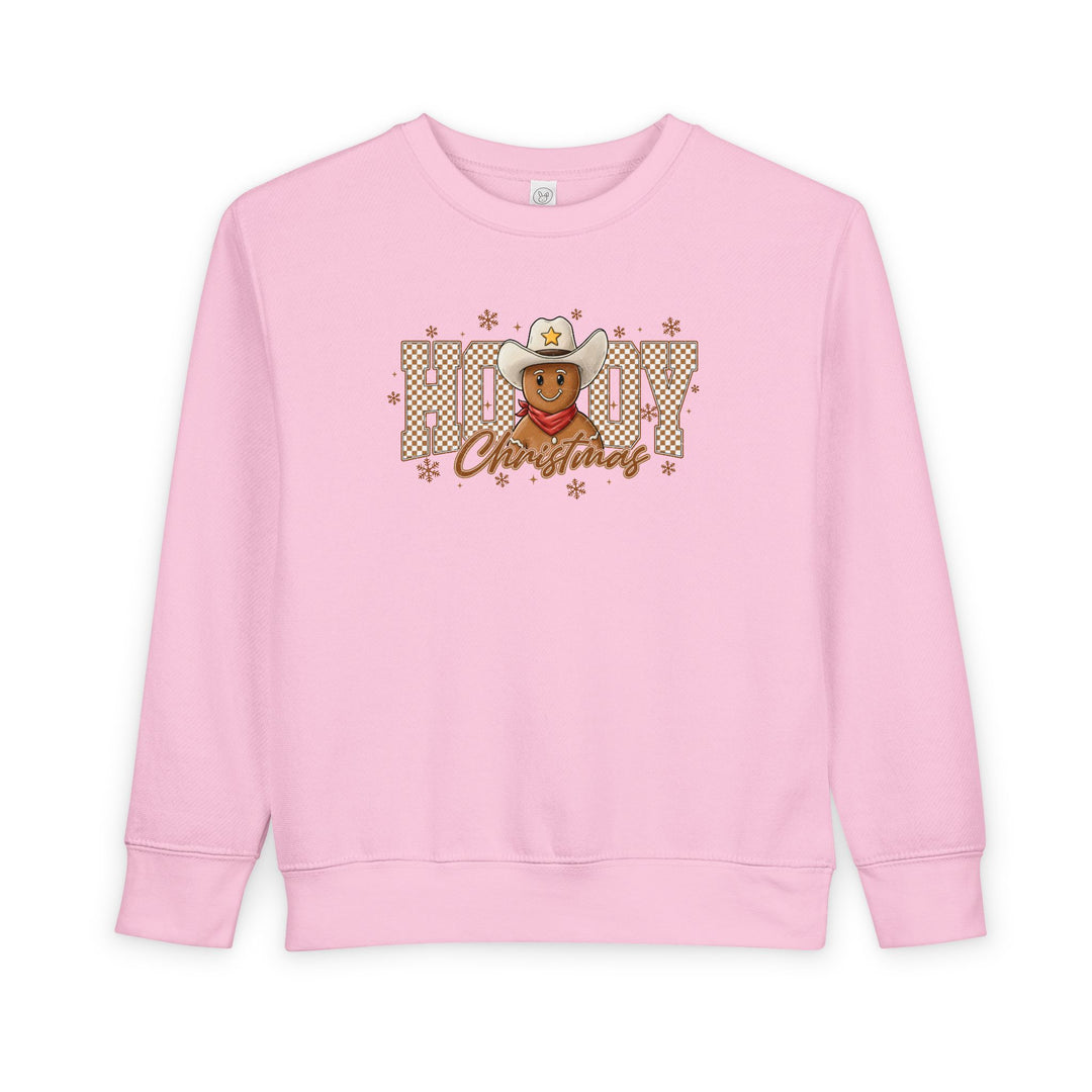 Light-pink toddler crewneck with a cowboy gingerbread design and Howdy Christmas in buffalo-check, featuring snowflakes. Cozy, soft fleece blend, ideal for festive comfort.