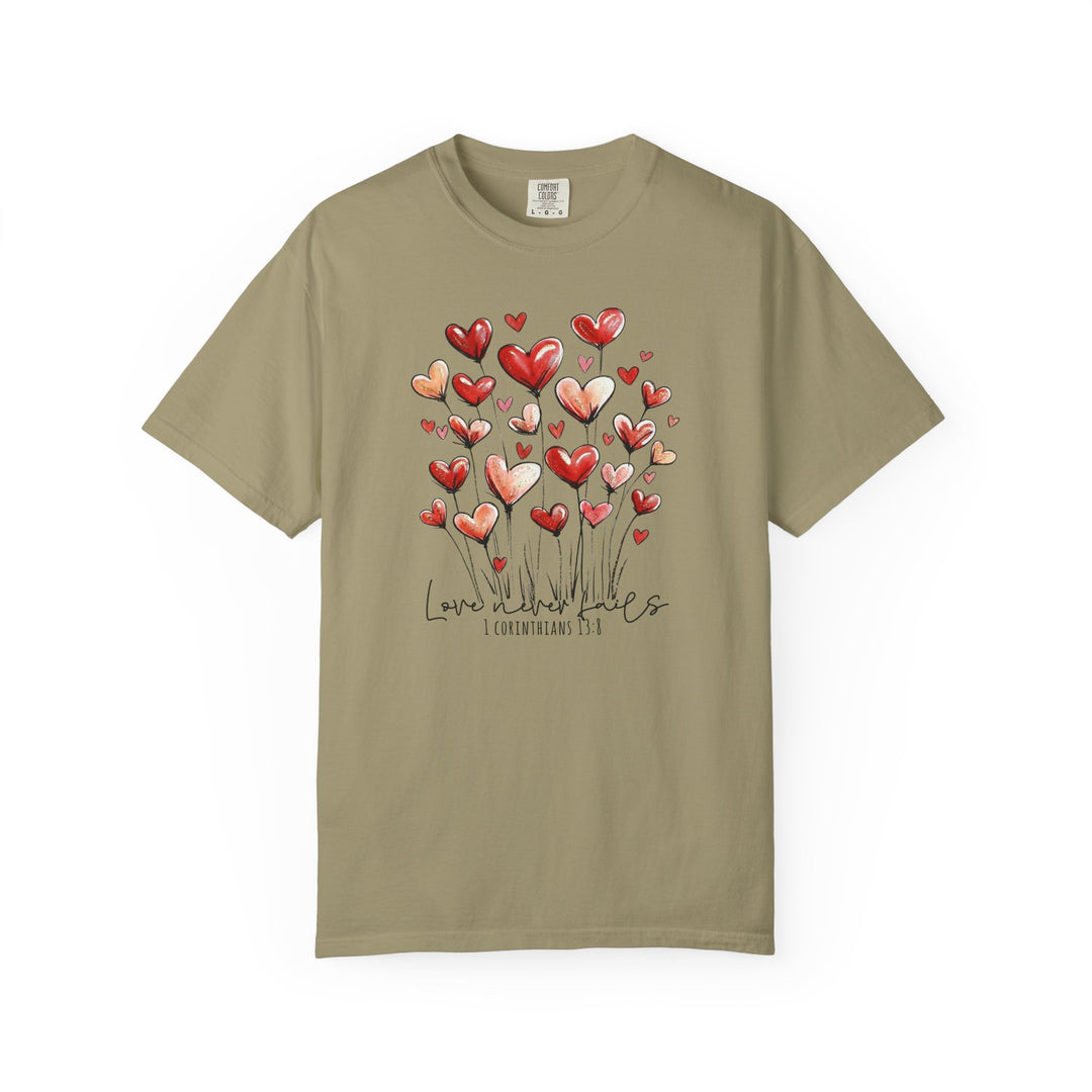 Love Never Fails Tee: Olive-green T-shirt featuring heart-shaped flowers and “Love never fails” text with Biblical reference, designed for comfort and style.