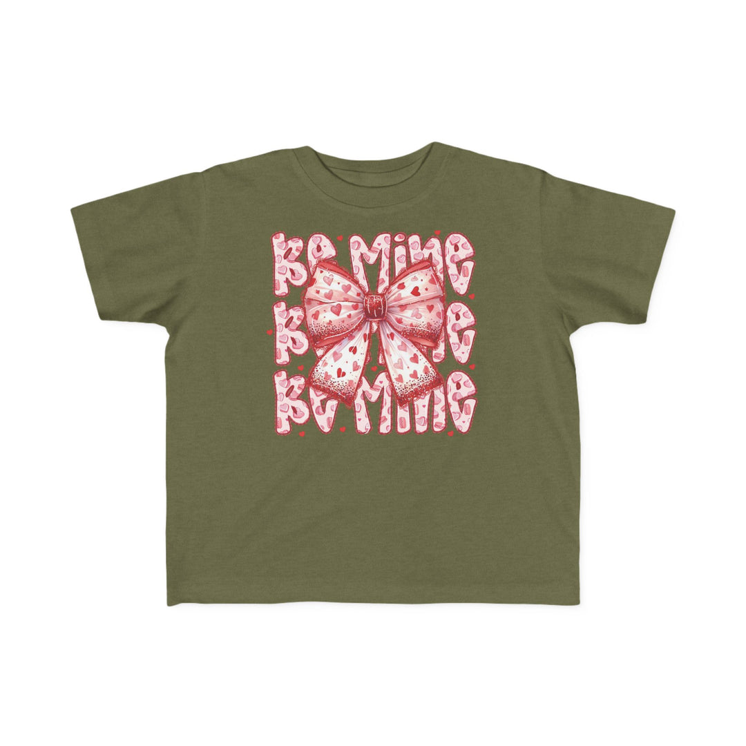 Be Mine Toddler Tee featuring an olive-green base with a pink-and-white heart bow and Be Mine in playful bubble letters, perfect for Valentine's Day.