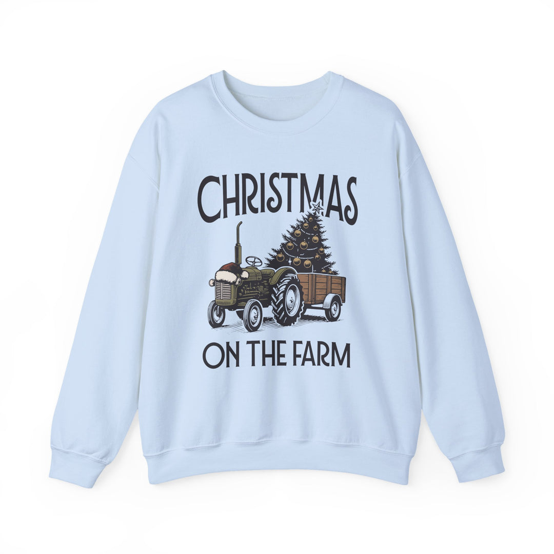 Light-blue crewneck sweatshirt featuring a festive tractor towing a decorated Christmas tree, with CHRISTMAS ON THE FARM text, ideal for cozy winter wear.