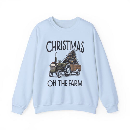 Light-blue crewneck sweatshirt featuring a festive tractor towing a decorated Christmas tree, with CHRISTMAS ON THE FARM text, ideal for cozy winter wear.