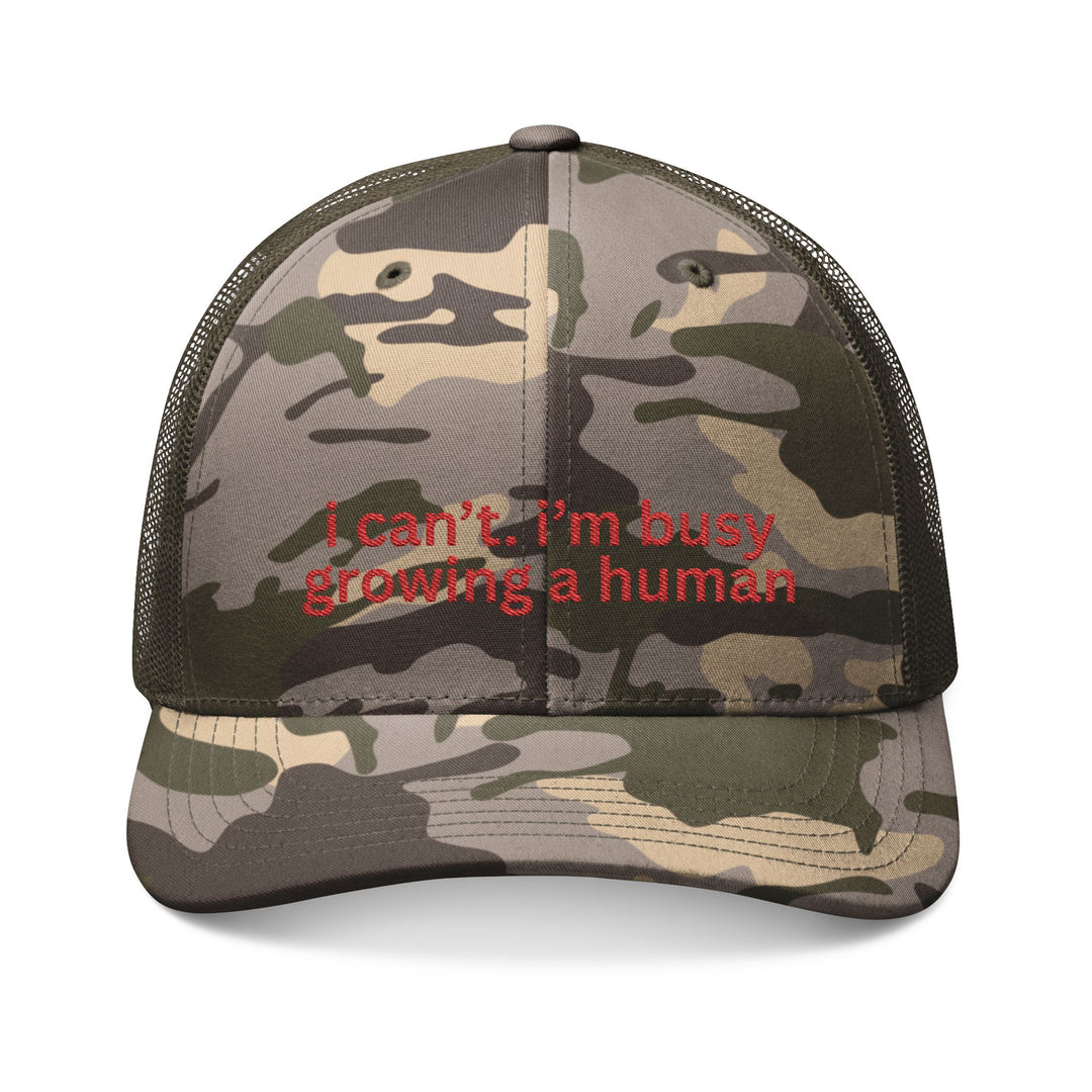 Camouflage-patterned trucker hat with mesh back, embroidered in red with i can’t. i’m busy growing a human. Perfect for comfort and style enthusiasts.