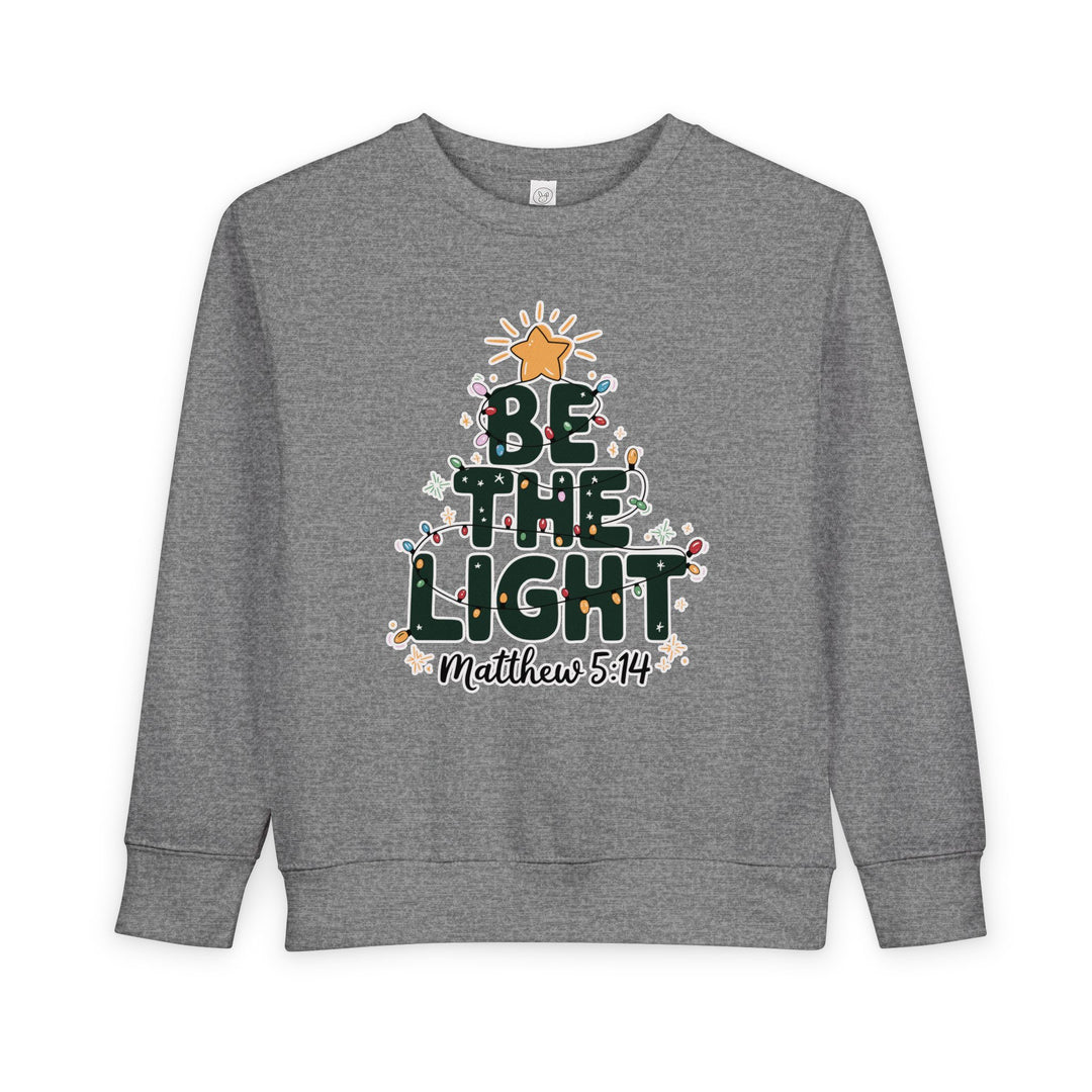 Gray crewneck sweatshirt featuring BE THE LIGHT in a Christmas tree shape with colorful lights and Matthew 5:14, designed for toddlers' comfort and style.