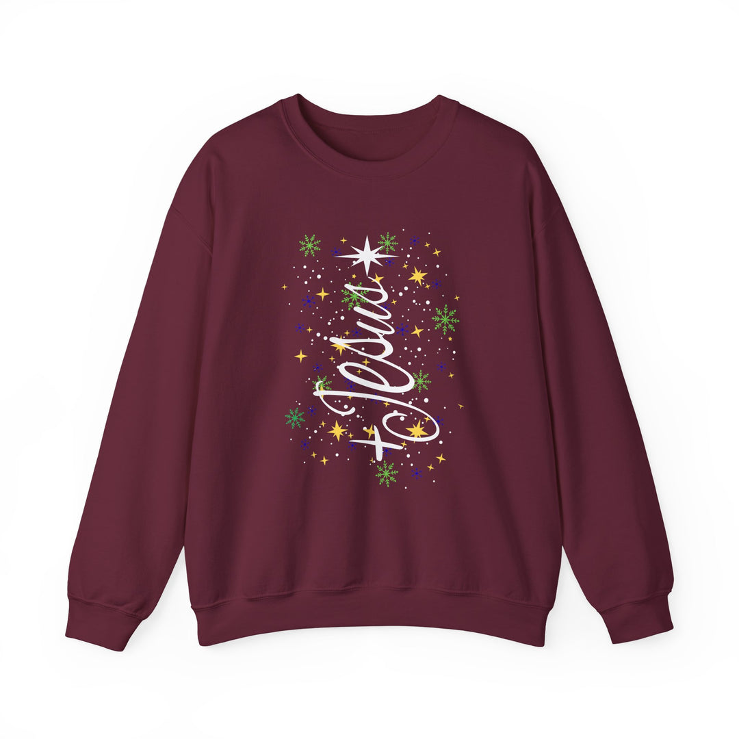 Maroon crewneck sweatshirt featuring Jesus script forming a Christmas tree with festive stars and snowflakes. Cozy, durable, ideal for cold weather.