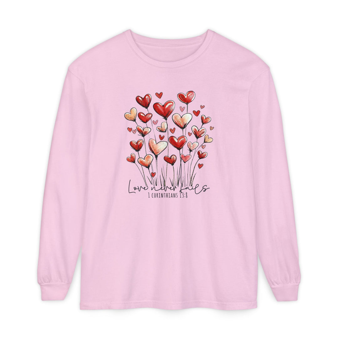 Love Never Fails Long Sleeve Tee with heart-flower graphic and scripture quote, made from soft ring-spun cotton for comfort and style.