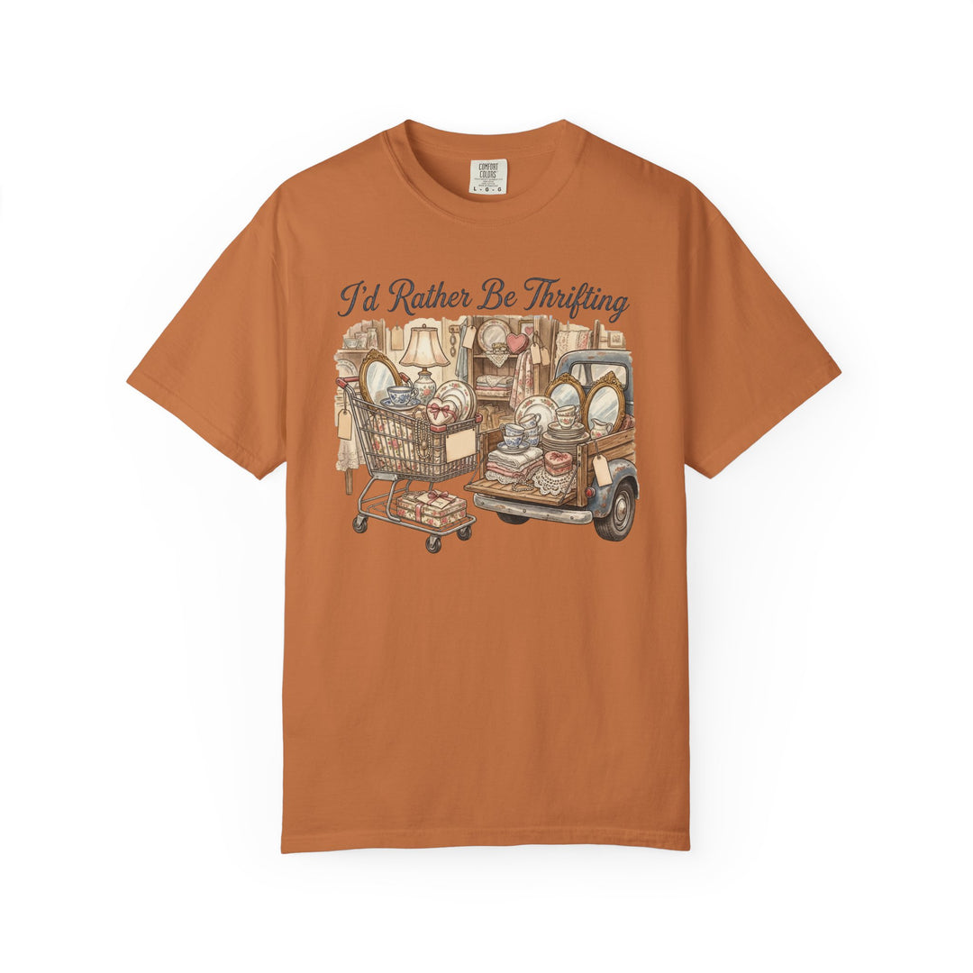 Rust-orange I'd Rather Be Thrifting T-shirt featuring vintage-style shopping cart and pickup truck illustration, highlighting stacked thrift-store finds. Relaxed fit, durable, 100% cotton.